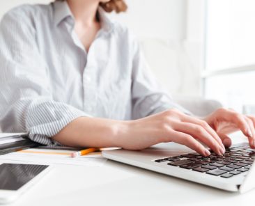 brunette-woman-typing-email-laptop-computer-while-sitting-home-selective-focus-hand